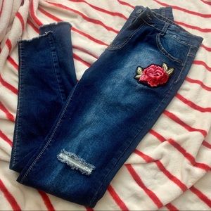 Dark blue jeans w/ rose embellishment / torn knee